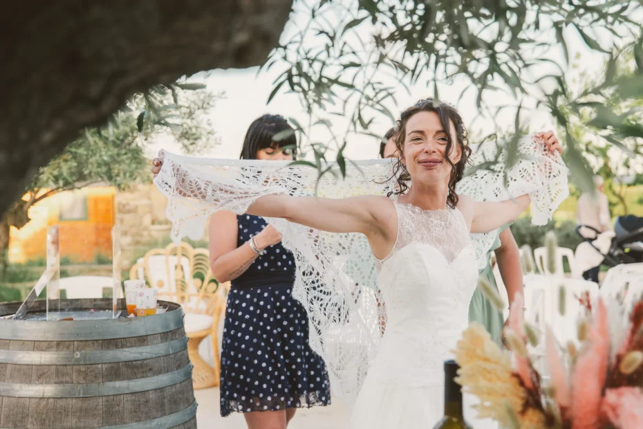 Lors d'un mariage au domaine Saint Augustin, proche de Rieux-Minervois en Occitanie, la mariée montre le voile de sa robe blanche aux témoins qui la prenne en photos.