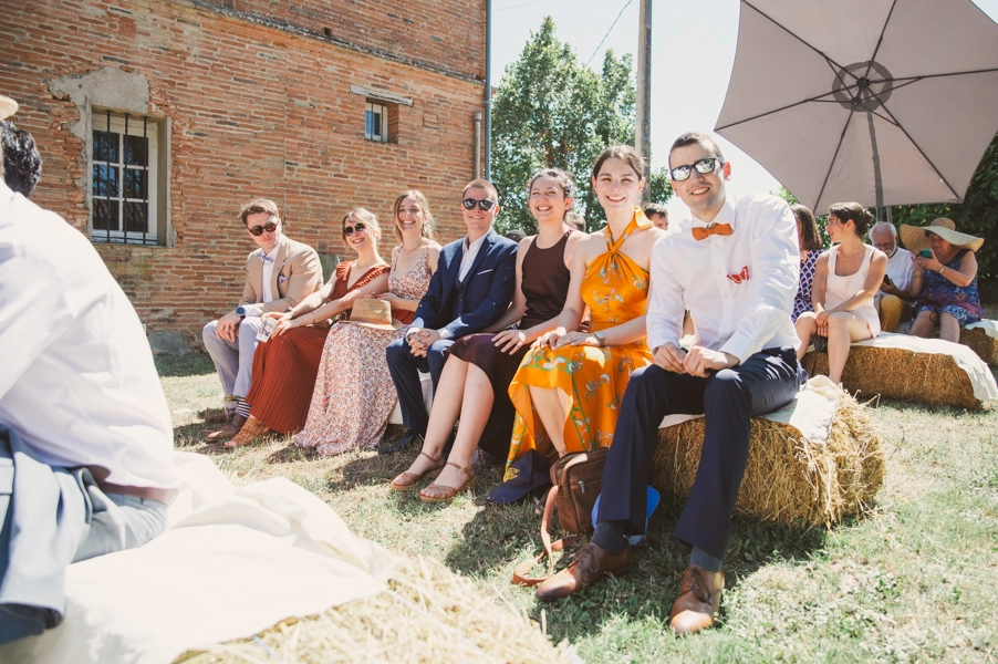 Les témoins des mariés sont assis sur les bancs de pailles lors de la cérémonie laïque.