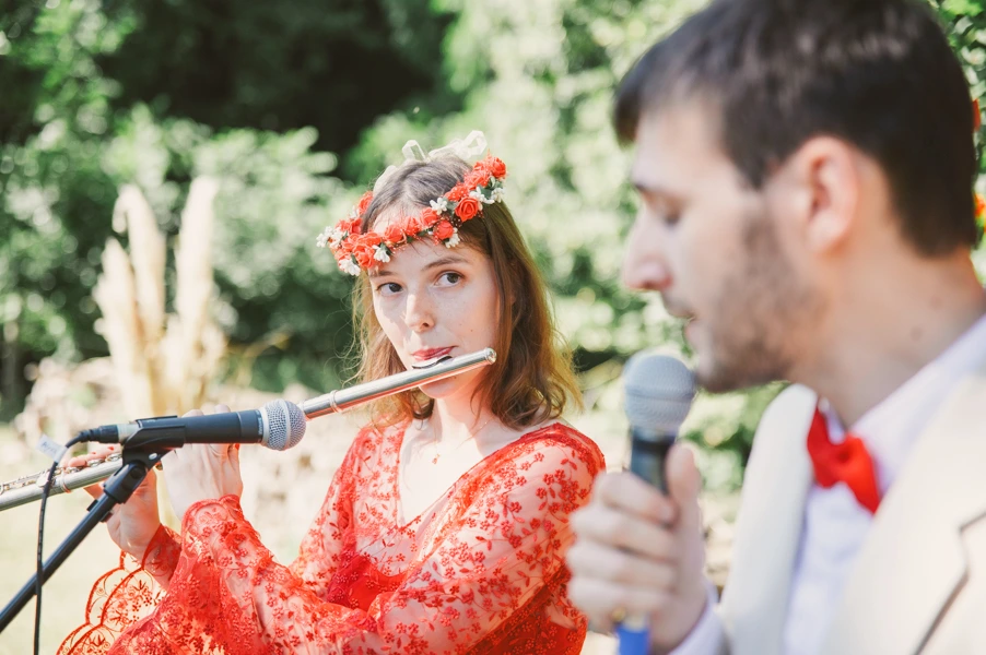 Les mariés jouent un morceau aux invités. La mariée à la flûte traversière et le mari à la voix