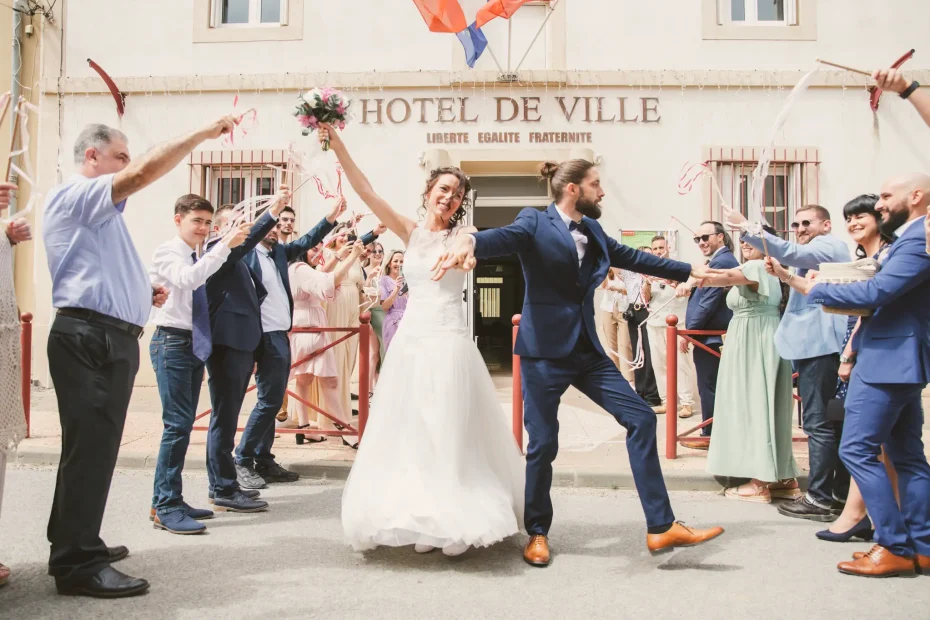 Photographe de mariage à Toulouse je photographie les mariés sortant de la mairie en dansant au milieu des invités.