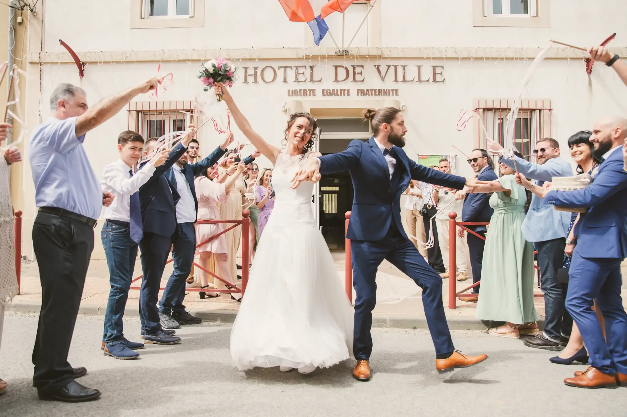 Photographe de mariage à Toulouse je photographie les mariés sortant de la mairie en dansant au milieu des invités.