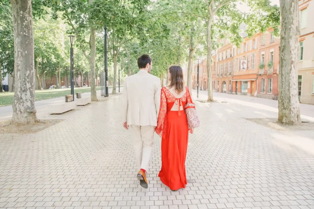 Photographe de mariage à Toulouse en séance day after avec un couple qui marche au milieu des allées Jules Guesde à Toulouse