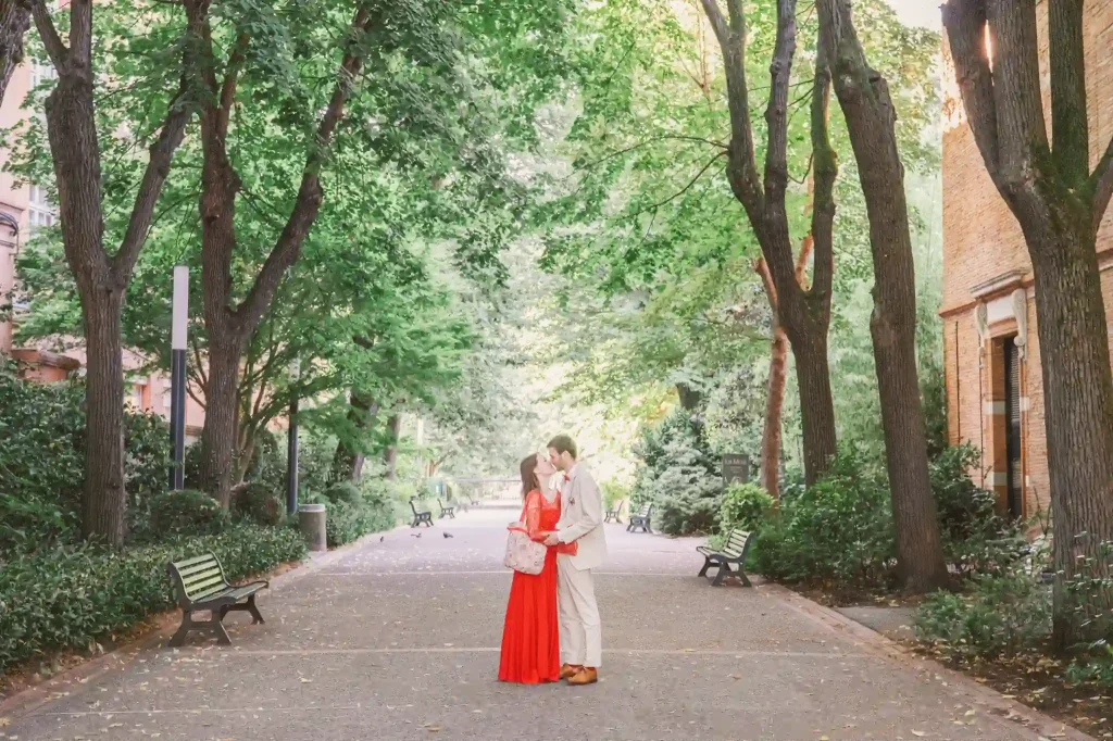 Photographe de mariage à Toulouse sur l'allée principale du jardin des plantes pour une séance day after avec des jeunes mariés qui s’enlacent devant le muséum de Toulouse. 