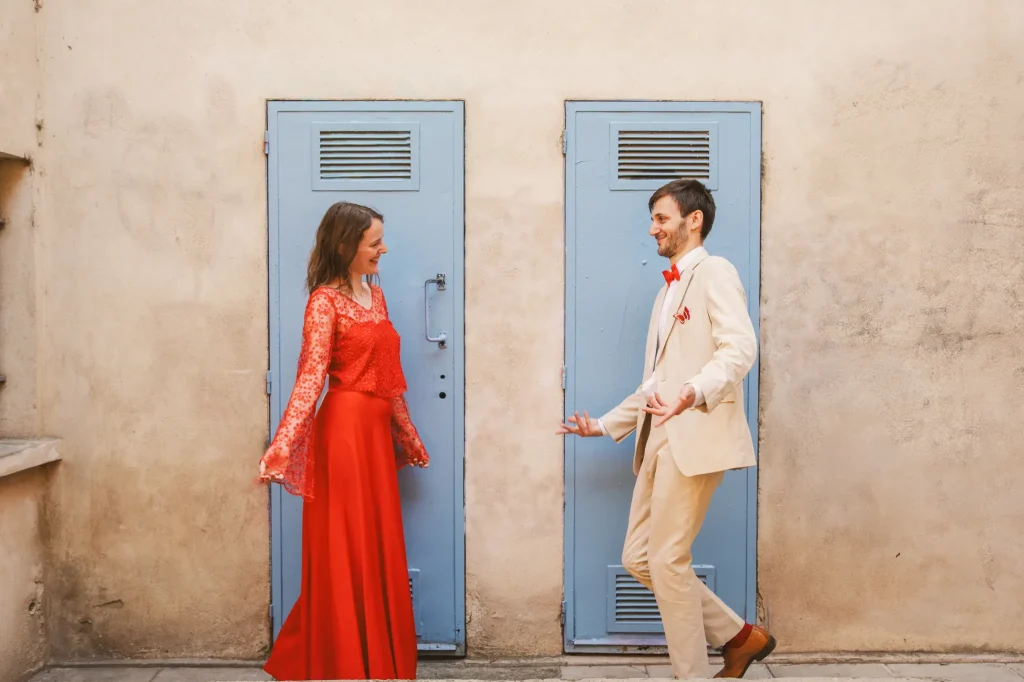 Photographe de mariage à Toulouse pour la day after d'Auriane et Victor qui se font des révérences devant des portes métalliques bleues