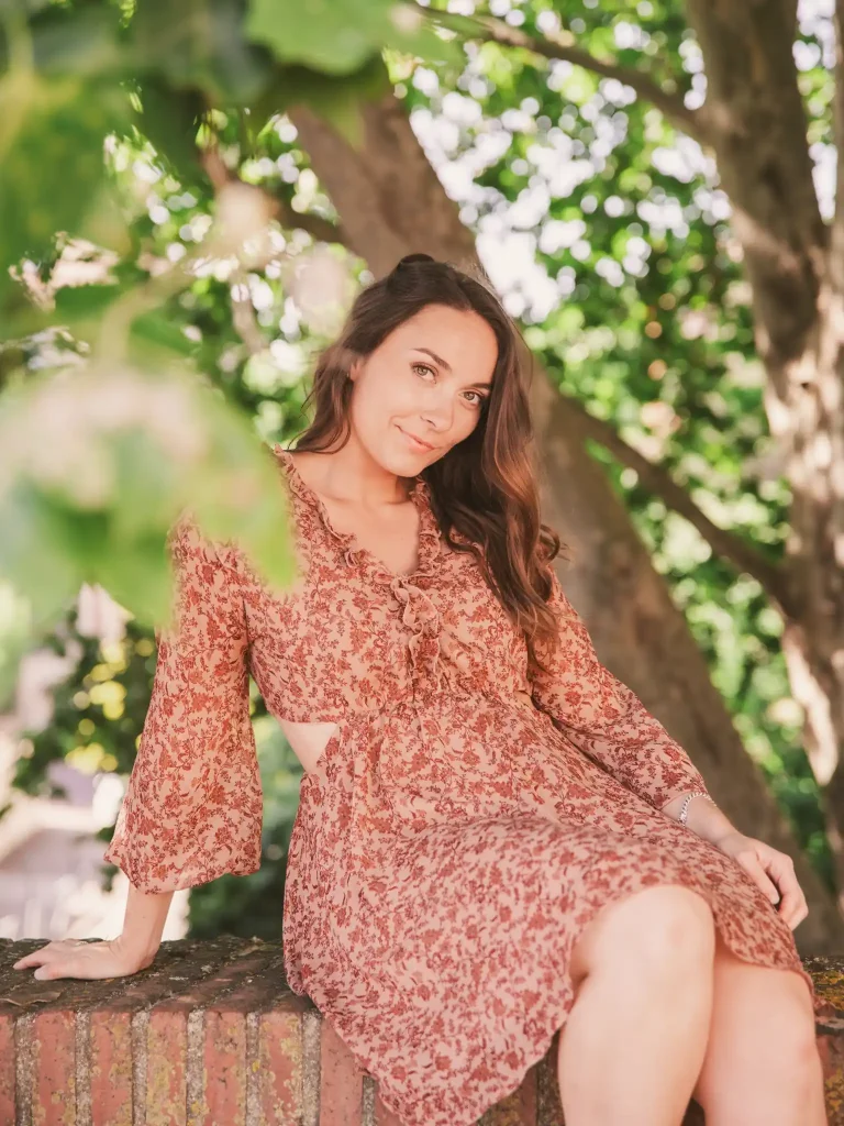 Séance photo portrait à Toulouse avec Claire assise sur le muret du pont de Tounis avec les branches du platane en arrière plan.
