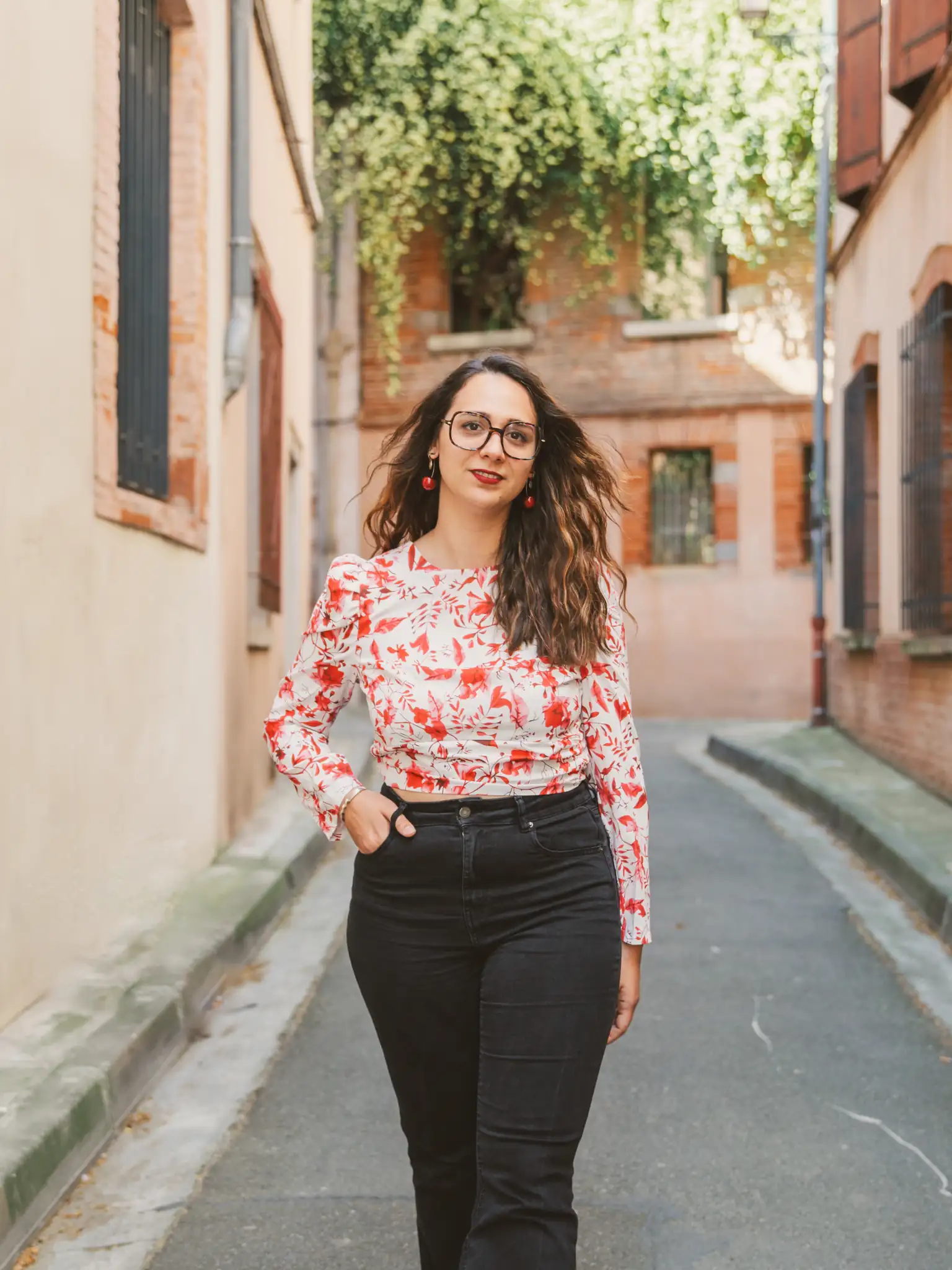 Séance photo portrait à Toulouse dans le quartier des Carmes avec Léa. Elle marche dans les rues étroites de la ville rose, une main dans la poche.