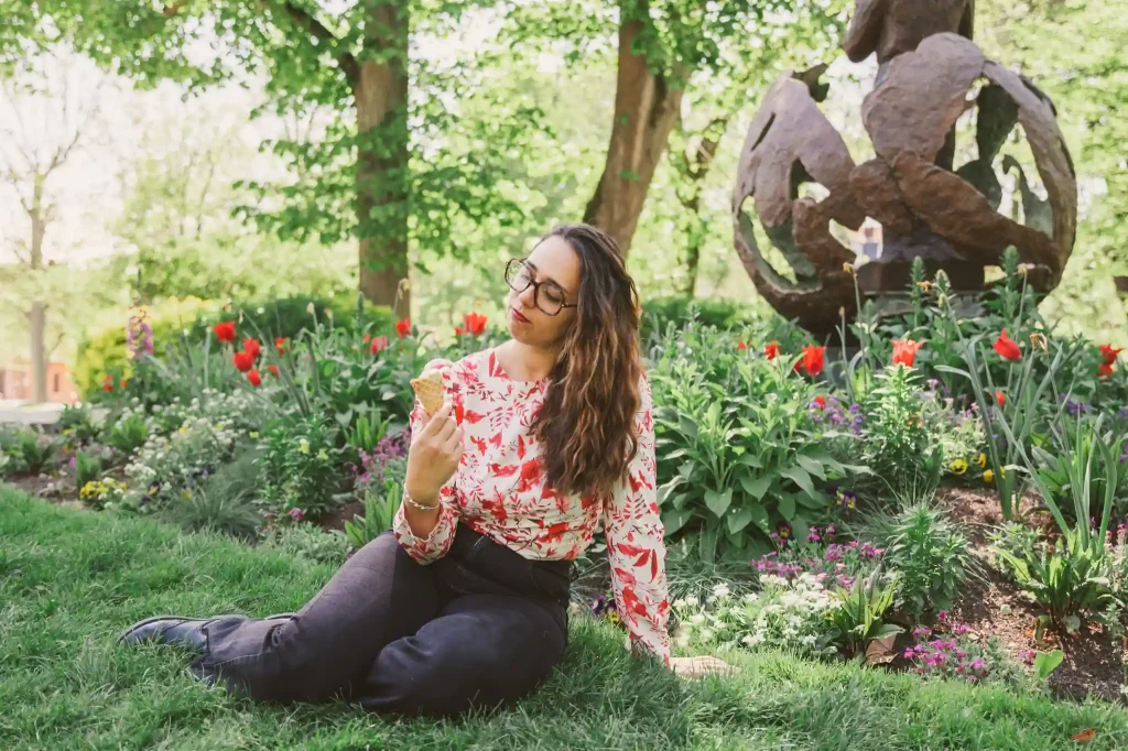 Séance photo portrait à Toulouse, au jardin des plantes avec Léa. Assise dans l'herbe, elle regarde sa glace avec envie.