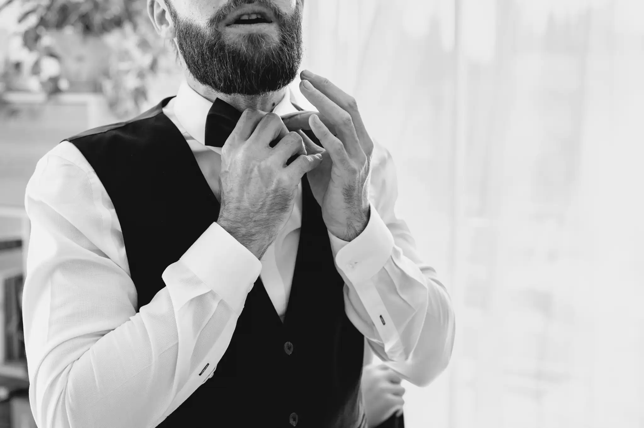 Photographe de mariage à Toulouse lors des préparatifs, le mariés ajuste son nœud papillon.