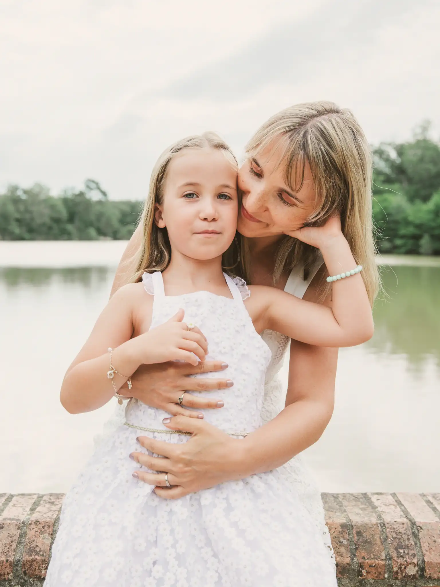 Séance famille à Toulouse dans la forêt de Bouconne. Sur un chemin dans les bois, la famille, en ligne, avance vers nous en souriant.