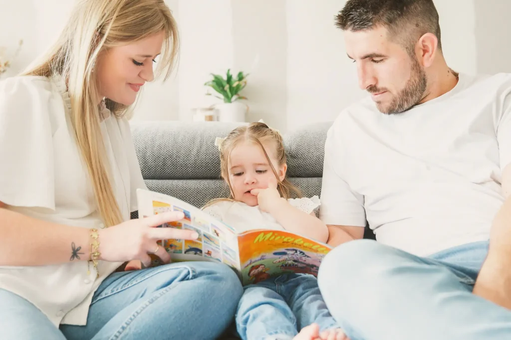 Séance photo famille à Toulouse avec une petite séance lecture dans le canapé.
