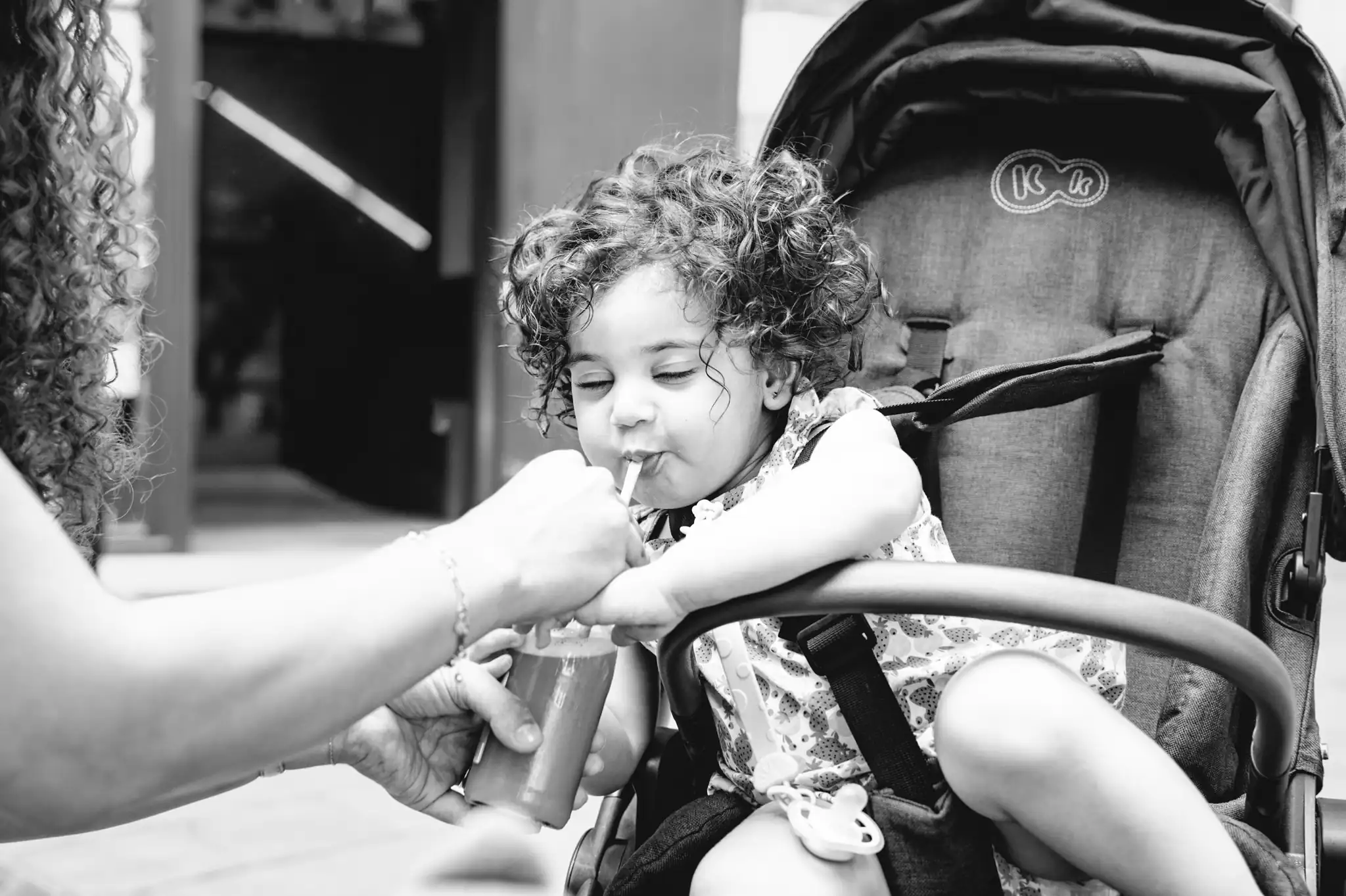 Séance photo famille à Toulouse au jardin des plantes avec les parents qui se roule dans l'herbe en riant aux éclats avec leur fille