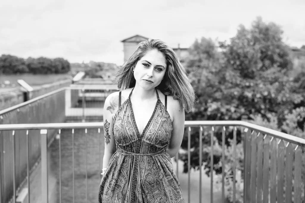 Séance photo portrait à Toulouse sur la digue du quartier Saint-Cyprien. La modèle photo pose les bras croisés devant l'Hôtel-Dieu