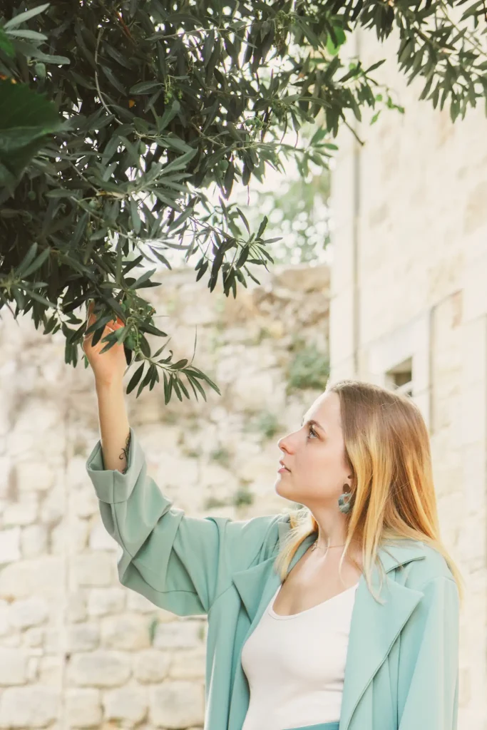 Séance photo portrait à Figeac. La modèle regarde les branches d'un olivier.