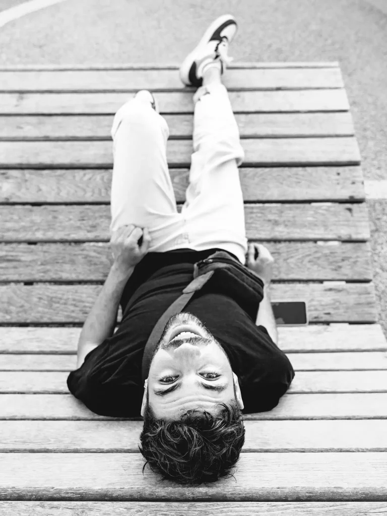 Séance photo portrait à Toulouse sur un banc du pont Saint-Pierre. Couché à l'envers, il nous regarde.