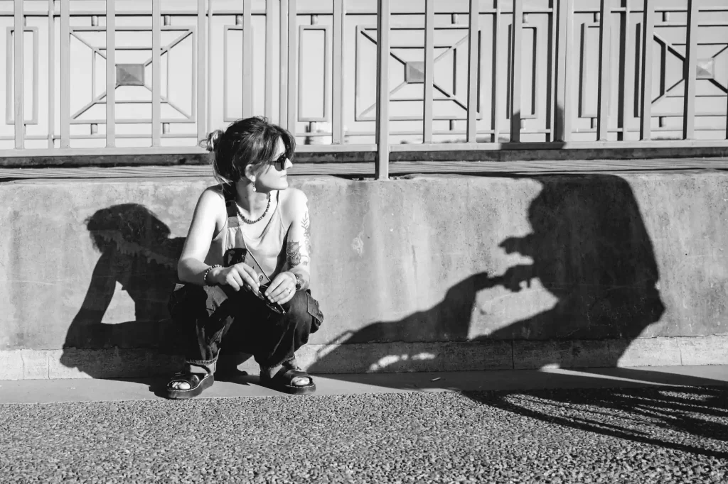 Séance photo portrait à Toulouse sur le pont saint-Pierre. Agenouillée, l'ombre d'un vélo lui fonce dessus