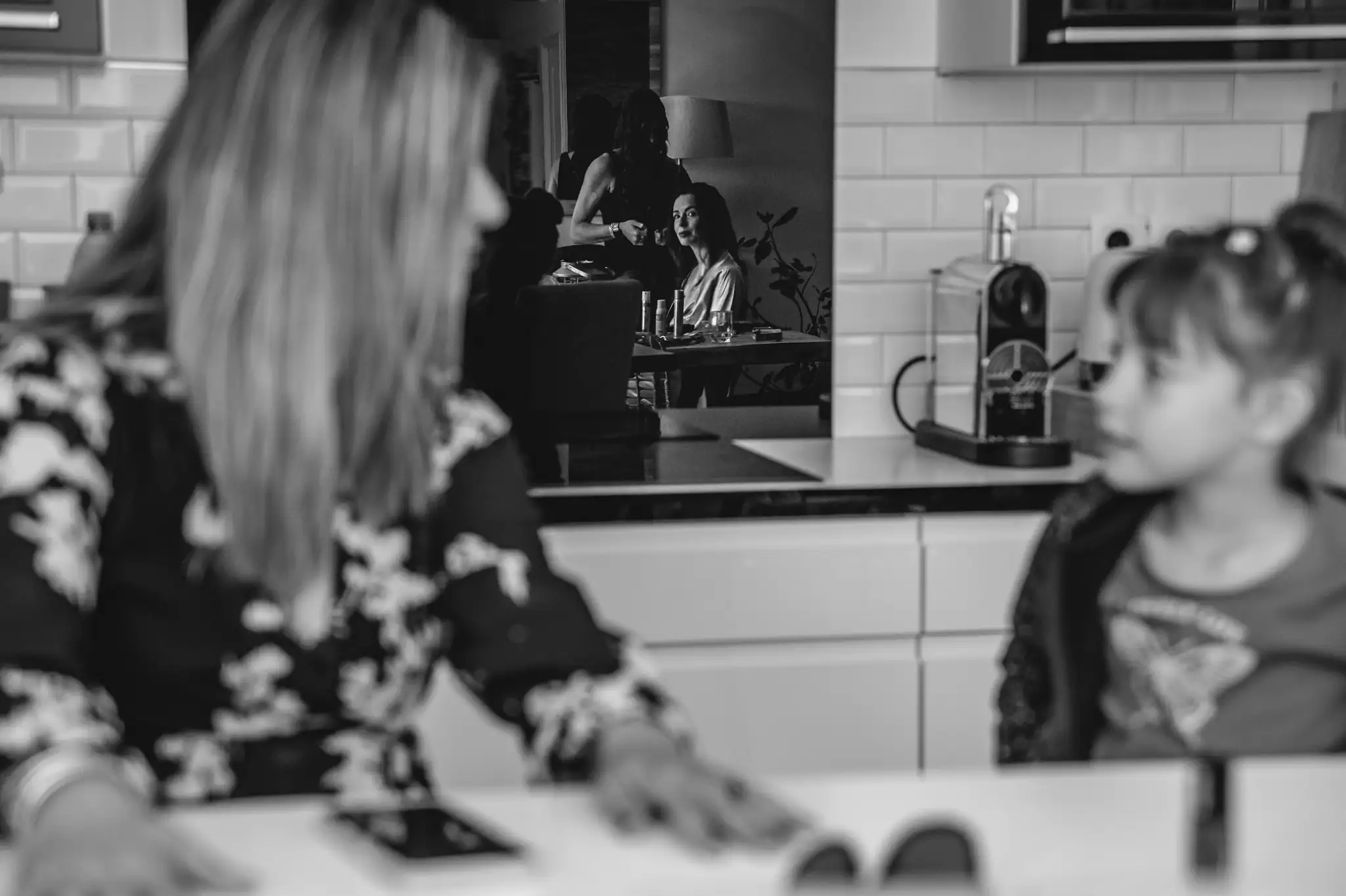 Photographe de mariage à Toulouse pendant les préparatifs. La mariée regarde sa fille dans le reflet du miroir pendant qu'elle se fait coiffer.