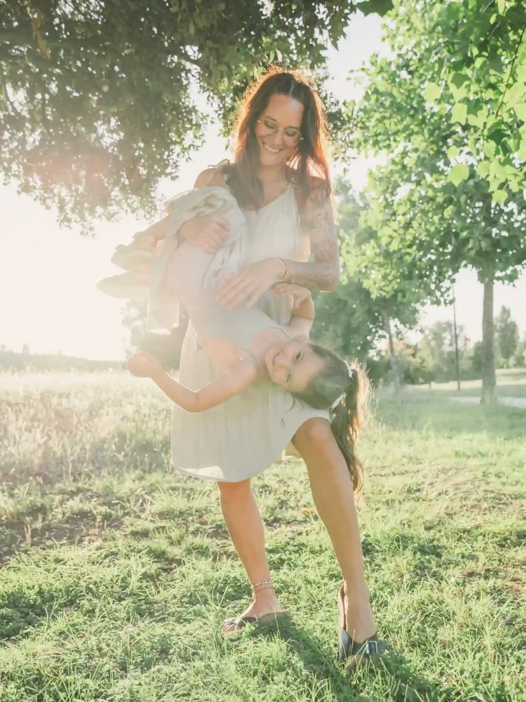 Séance photo famille à Toulouse avec la mère qui porte sa fille par les pieds 