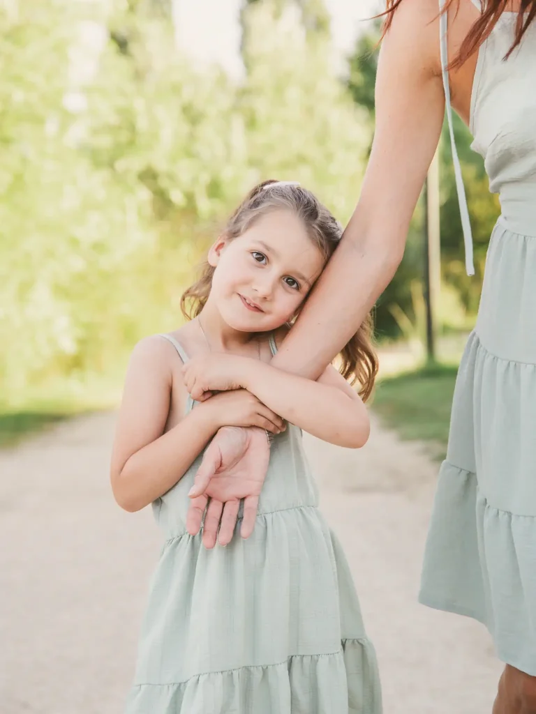 Séance photo famille à Toulouse : la fille fait un câlin à sa mère en marchant