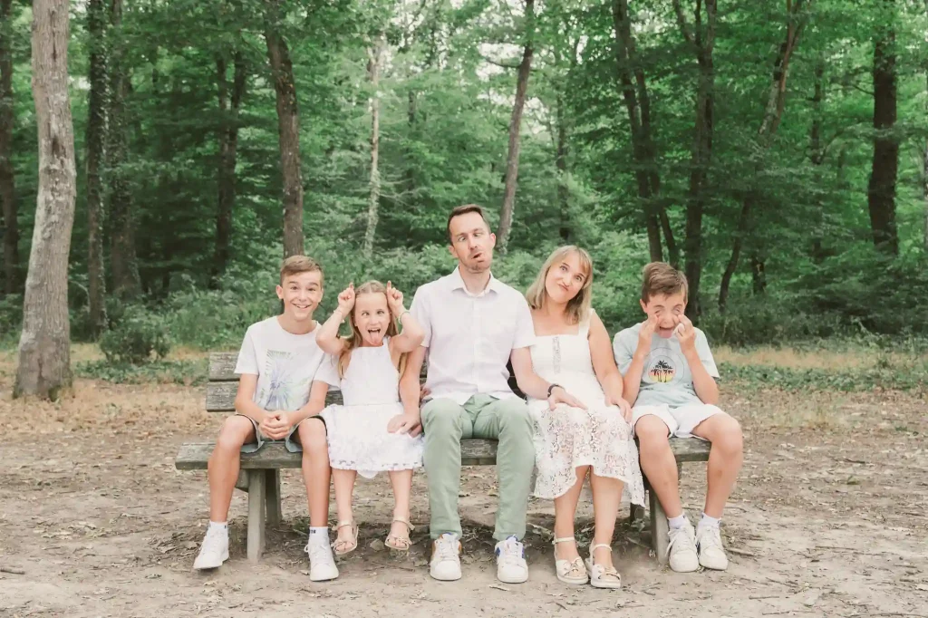 Séance Photo Famille à Toulouse dans la forêt de Bouconne avec une photo pleine de grimaces pour une photo de famille drôle et originale.