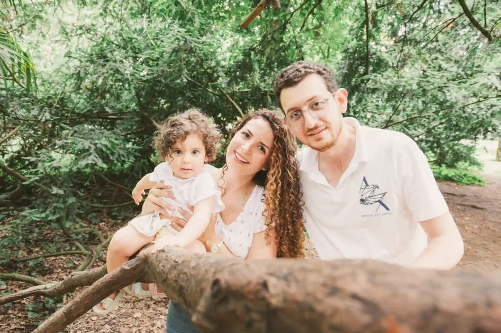 Séance photo famille à Toulouse au jardin des plantes. La famille pose dans les arbres pour la photo