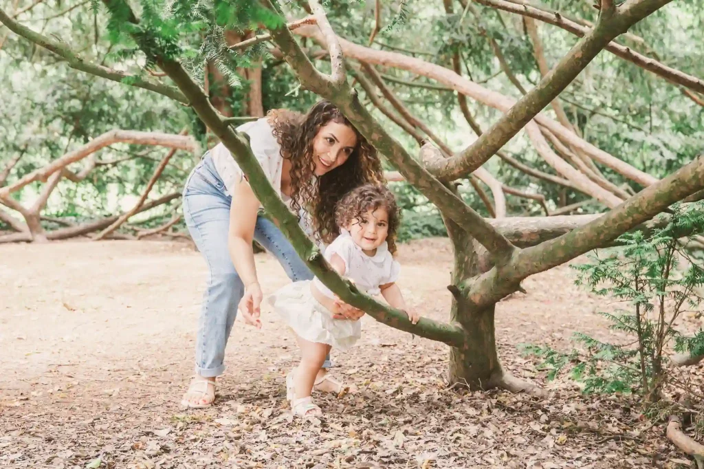 Séance photo famille à Toulouse au jardin des plantes avec la fille qui grimpe aux arbres sous le regard vigilant de sa maman