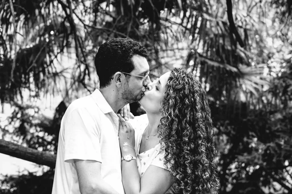 Séance photo famille à Toulouse au jardin des plantes avec les parents qui s'embrassent amoureusement