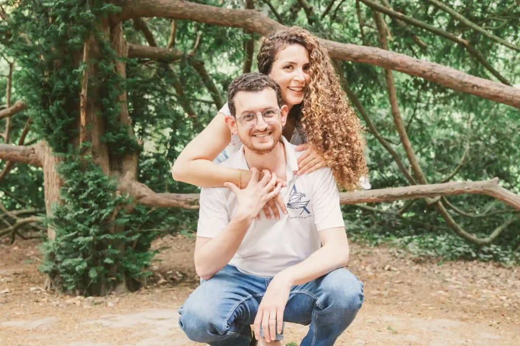 Séance photo famille à Toulouse au jardin des plantes avec une photo de couple des parents qui s'agenouillent.