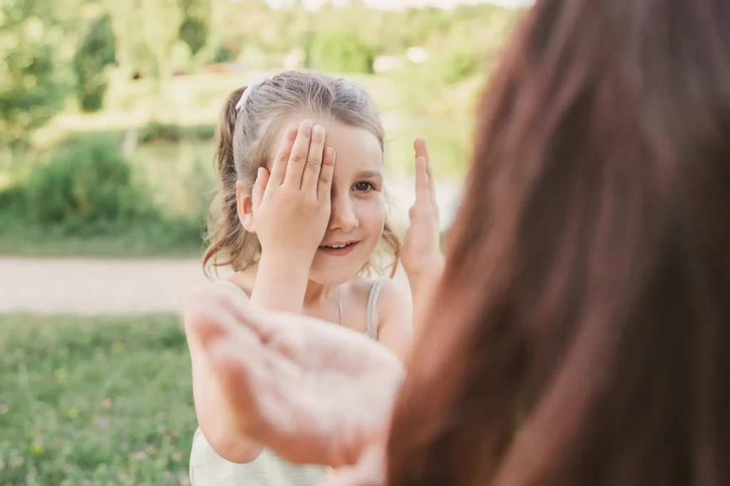Séance photo famille à Toulouse dans le parc de loisir de Bruguières, la mère et sa fille jouent dans l'herbe
