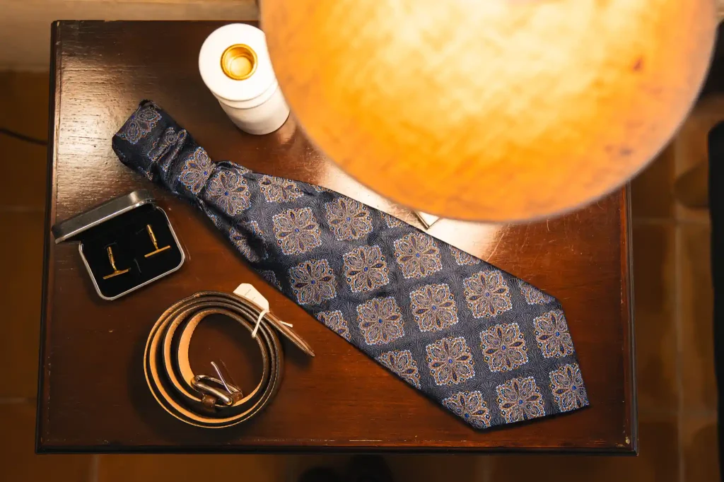 Le photographe de mariage a disposé les accessoires de la tenue du marié sur la table basse afin d'en faire une photo.