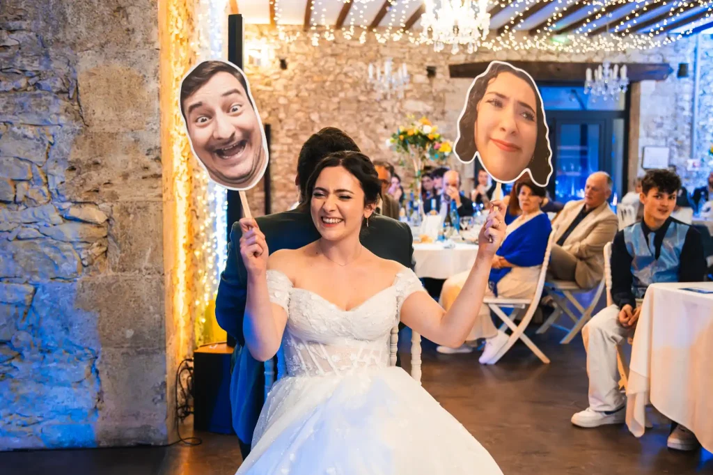 Pendant l'animation du repas du mariage, la mariée lève les deux pancartes en riant