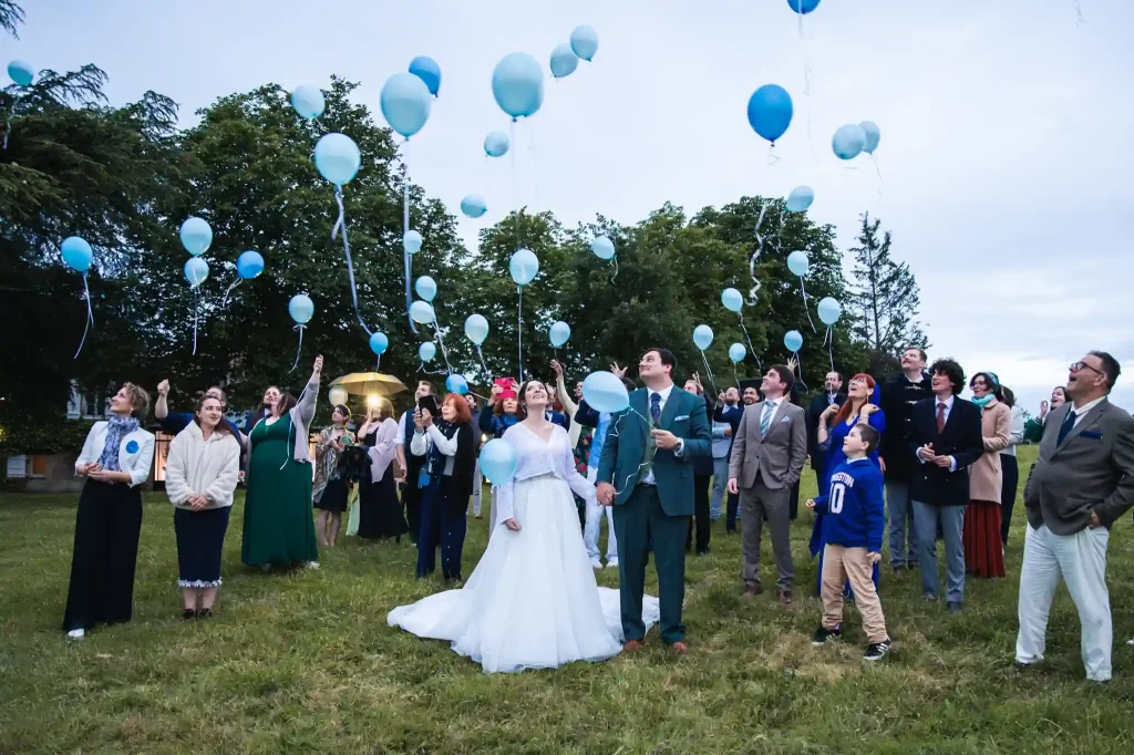 Les invités et les mariés lâchent les ballons simultanément pour un lancer de ballon à la Chartreuse de Dane