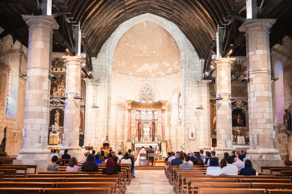 Les mariés assis devant l'hôtel de l'église Sainte-Fauste du Fezensac pendant que le prêtre débute la cérémonie religieuse.