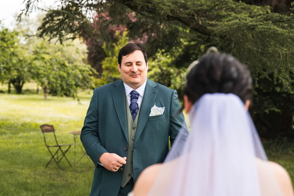 Le marié ému, le souffle coupé en se retournant et découvrant sa femme dans sa robe de mariée.