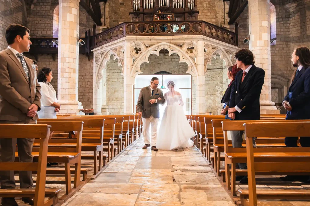 La mariée et son père remonte l'allée centrale vers l’hôtel de l'église Sainte-Fauste du Fezensac