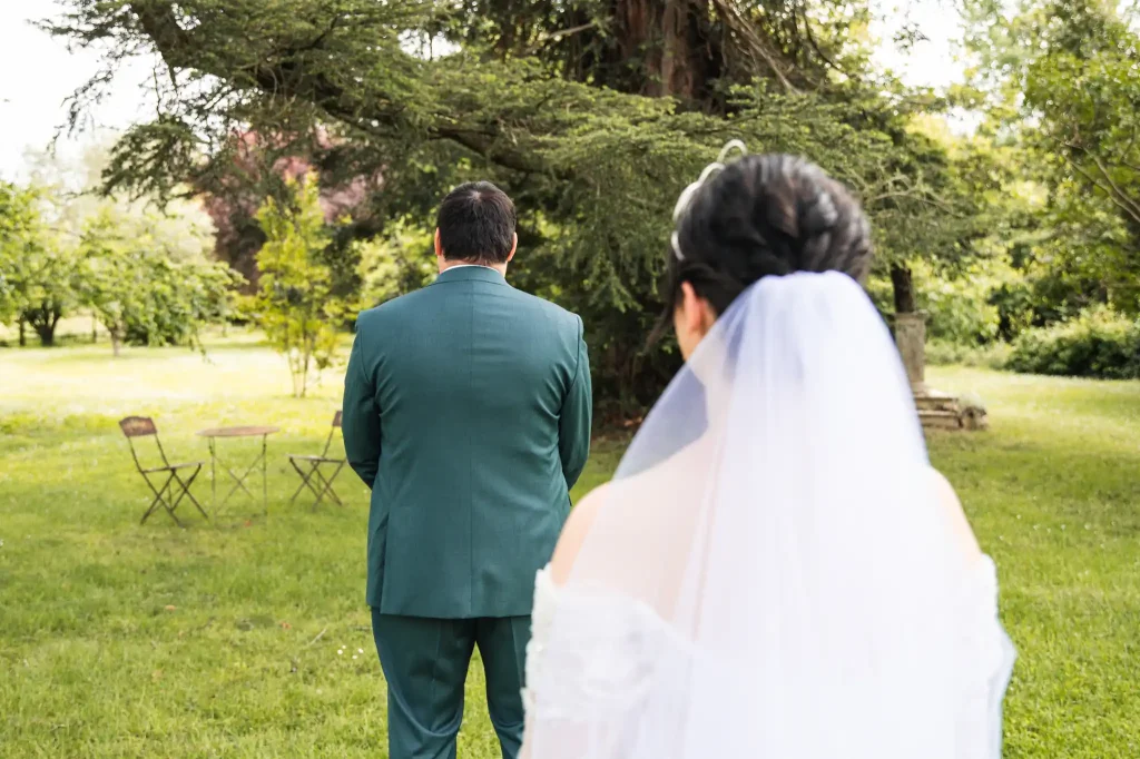 Le marié, dos à sa femme prend une grande inspiration avant de se retourner et découvrir la tenue de la mariée.