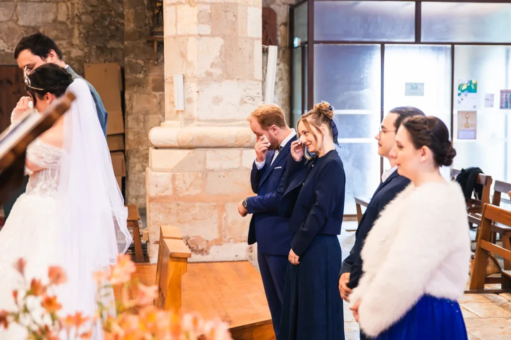 Les témoins, émus pendant la cérémonie religieuse de mariage, s'essuient les larmes qu'ils laissent échapper.
