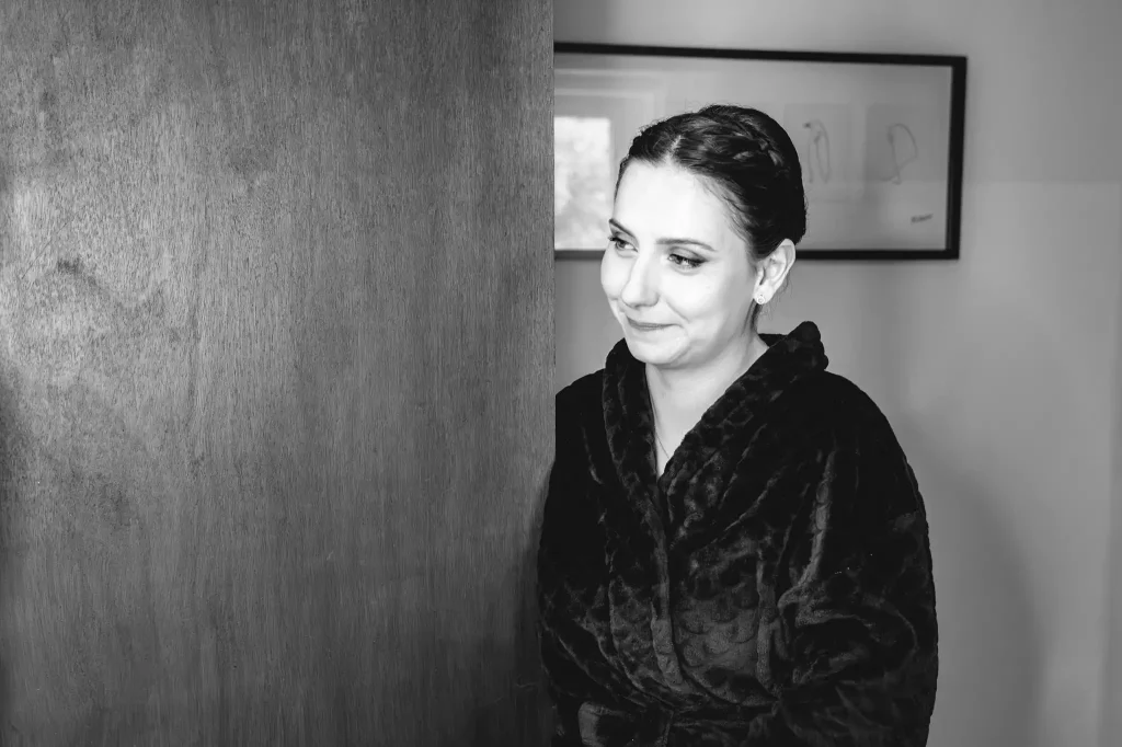 La demoiselle d'honneur regarde avec beaucoup d'émotions la mariée qui se fait maquiller